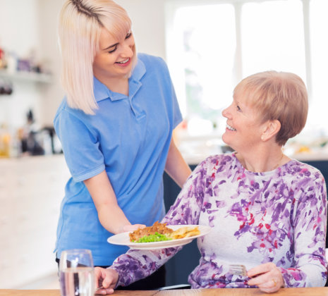 Caretaker preparing food for resident